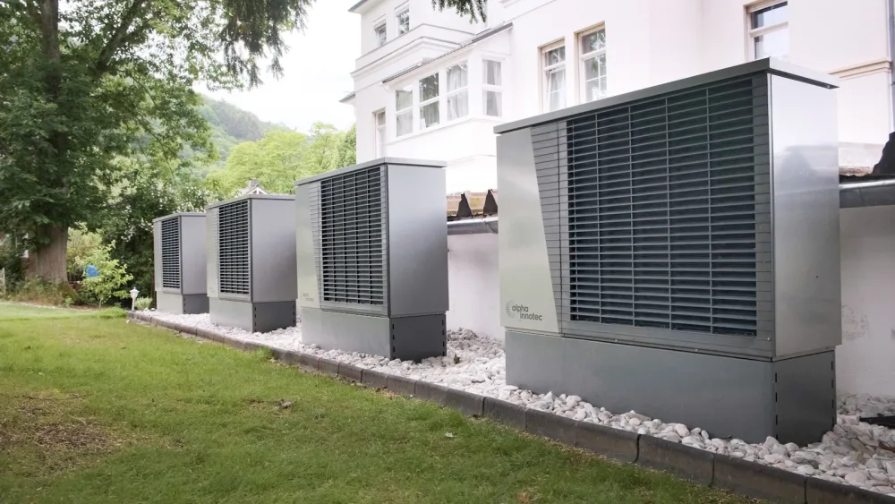 Four industrial air conditioning units lined up outside building
