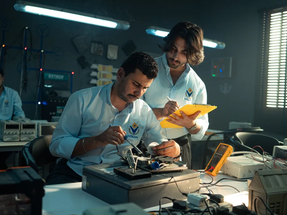 Focused technicians collaborate in an electronics lab, emphasizing teamwork and innovation.