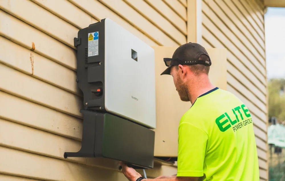 A skilled technician working on the installation of a solar inverter system outdoors. Energy efficiency solution.