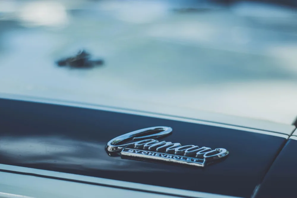 Detailed view of a Chevrolet Camaro emblem on a car hood, perfect for automotive enthusiasts.