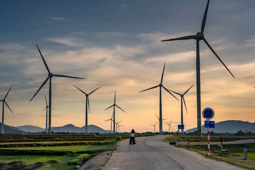 A scenic view of a wind farm with turbines under a vibrant sunset sky, highlighting renewable energy.