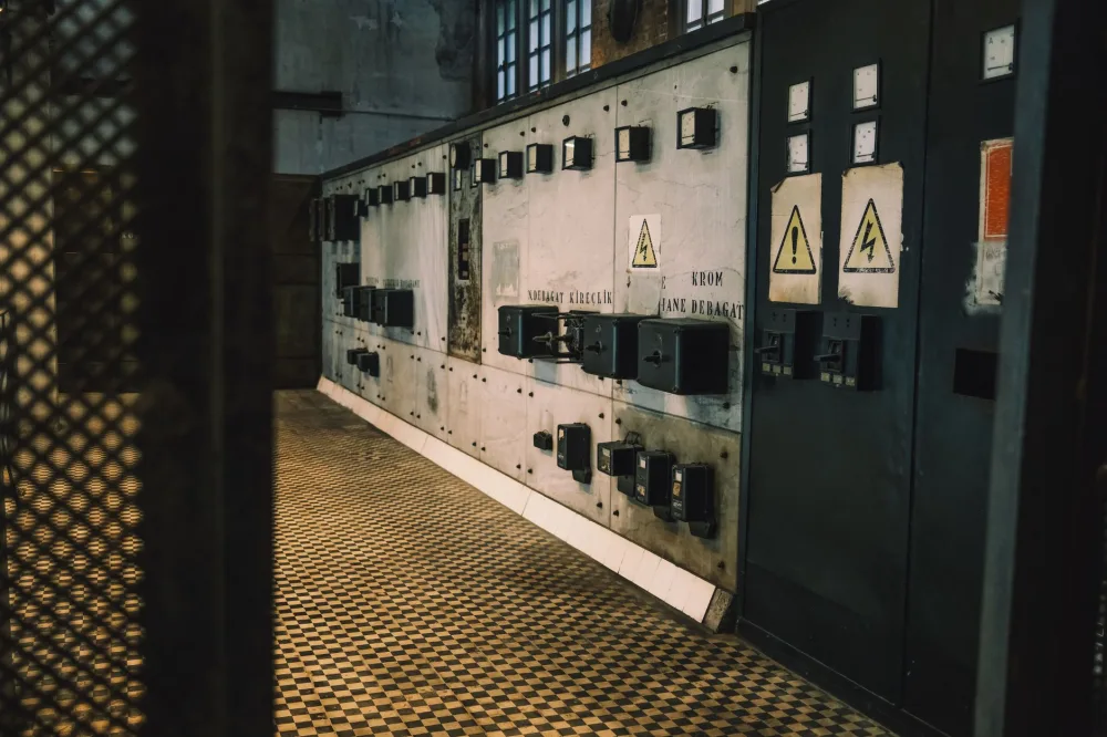 Vintage industrial control panel with warning signs in a dimly lit room, creating a moody atmosphere.